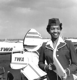 Dorothy Franklin posing in front of a TWA Airplane